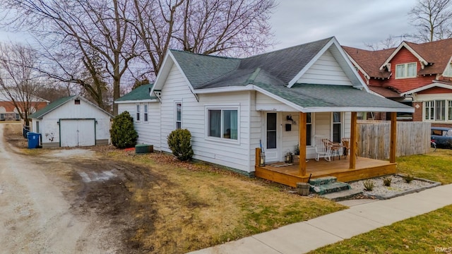 bungalow-style house with a garage, an outdoor structure, a front lawn, and covered porch