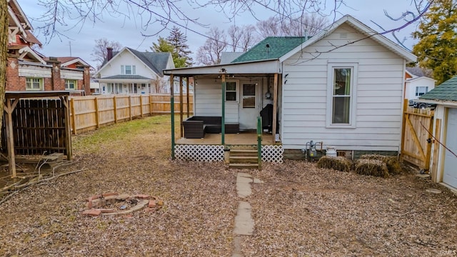 back of house with a porch and an outdoor fire pit