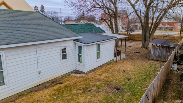 view of home's exterior with a yard and a storage unit