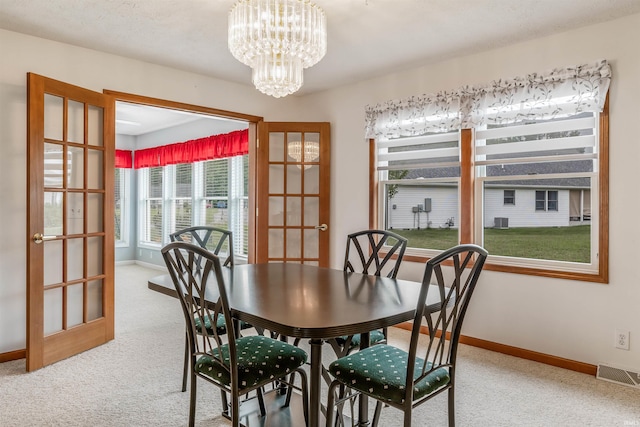 carpeted dining space featuring a notable chandelier