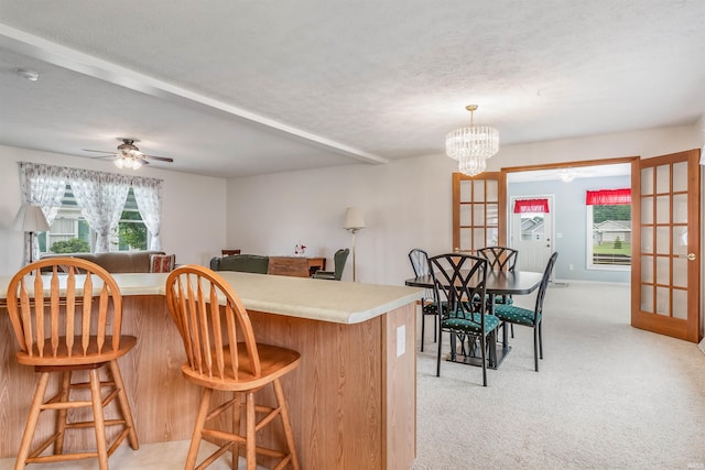 kitchen featuring light carpet, a wealth of natural light, french doors, and a textured ceiling