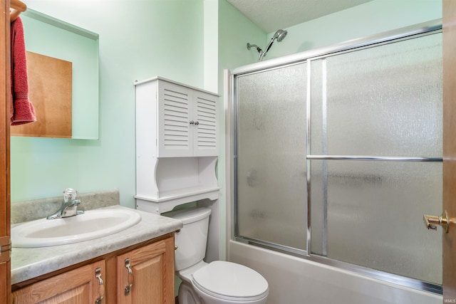 full bathroom with enclosed tub / shower combo, vanity, and toilet