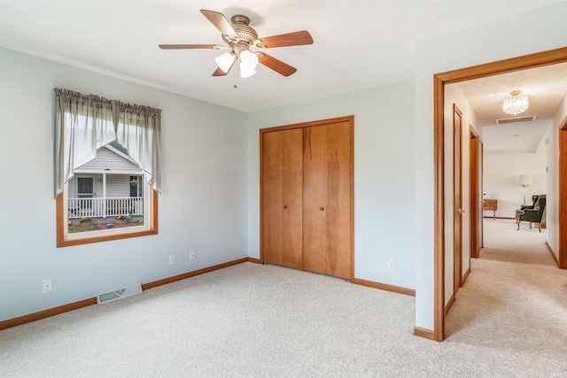 unfurnished bedroom with light colored carpet, a closet, and ceiling fan