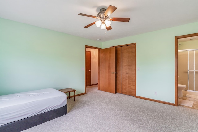 bedroom with ensuite bath, light colored carpet, a closet, and ceiling fan