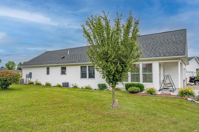 back of house with central AC, a yard, and a garage