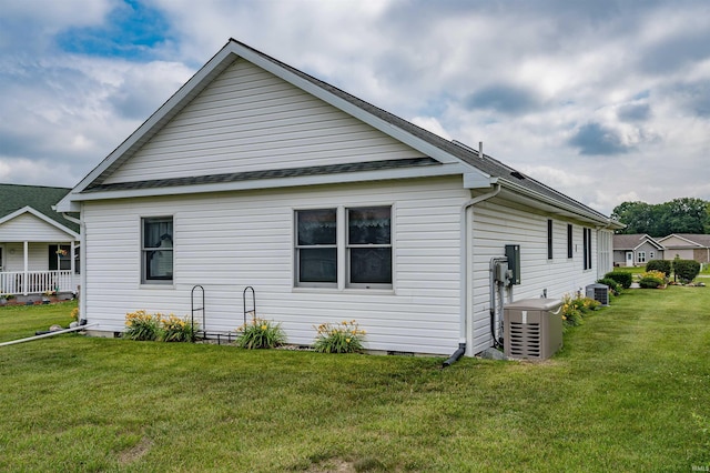 view of side of property with a lawn and central air condition unit