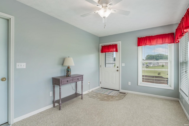 carpeted entrance foyer featuring ceiling fan