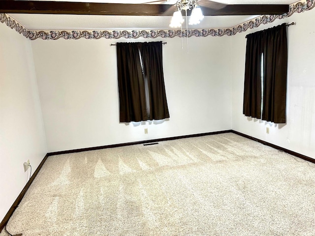 carpeted spare room featuring ceiling fan and beam ceiling