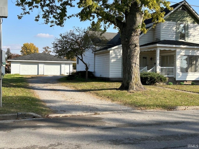 view of side of property with an outbuilding, a porch, a garage, and a lawn