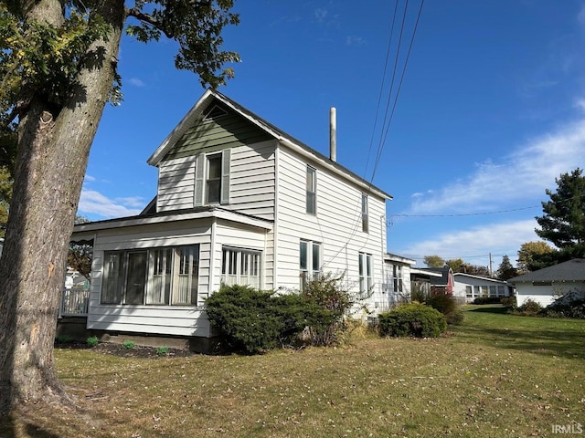 view of side of home with a lawn