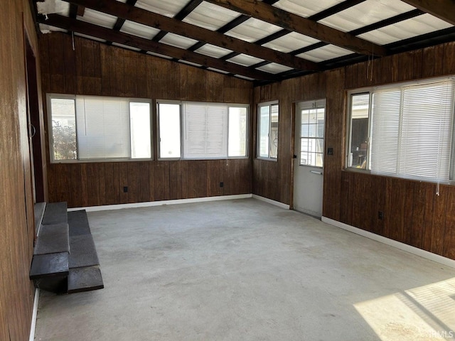 unfurnished sunroom with lofted ceiling with beams