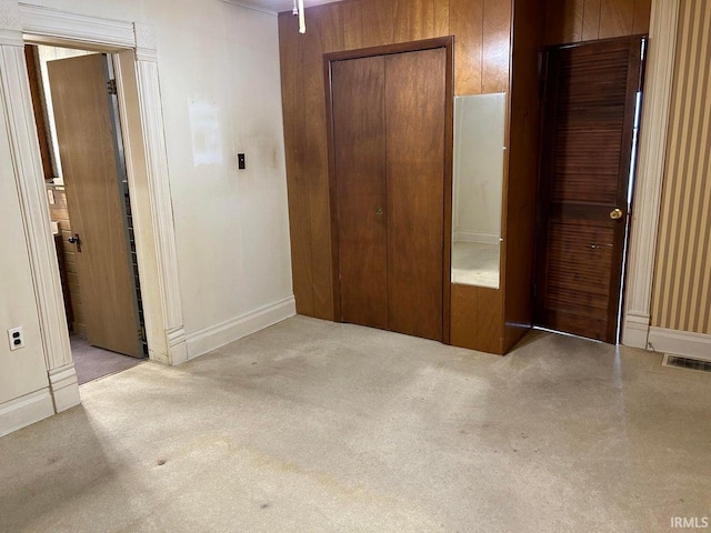 unfurnished bedroom with light carpet and a closet