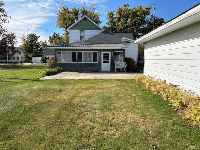 rear view of house featuring a yard and a patio