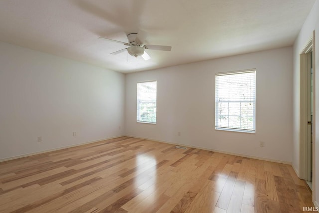 spare room with ceiling fan and light wood-type flooring