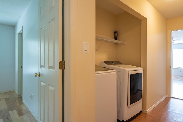 laundry room featuring washer and clothes dryer and light hardwood / wood-style floors