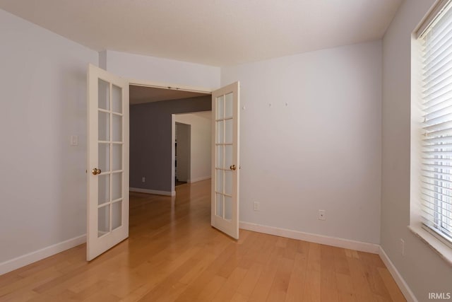 spare room featuring light hardwood / wood-style flooring and french doors