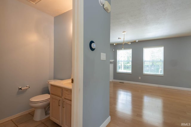 bathroom with vanity, hardwood / wood-style floors, a textured ceiling, and toilet