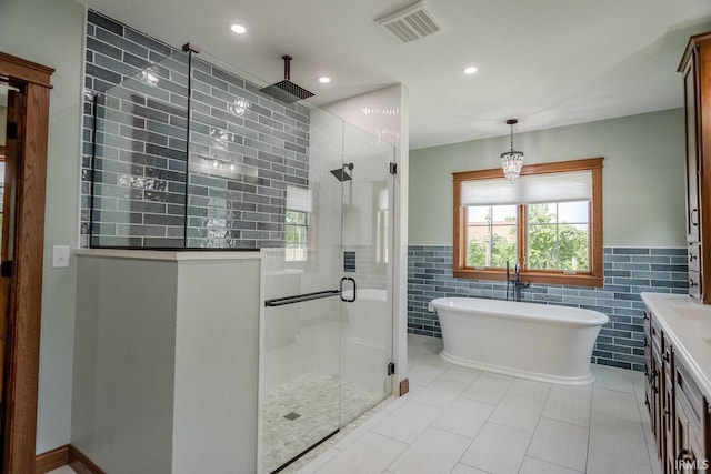 bathroom featuring tile walls, vanity, tile patterned floors, and separate shower and tub