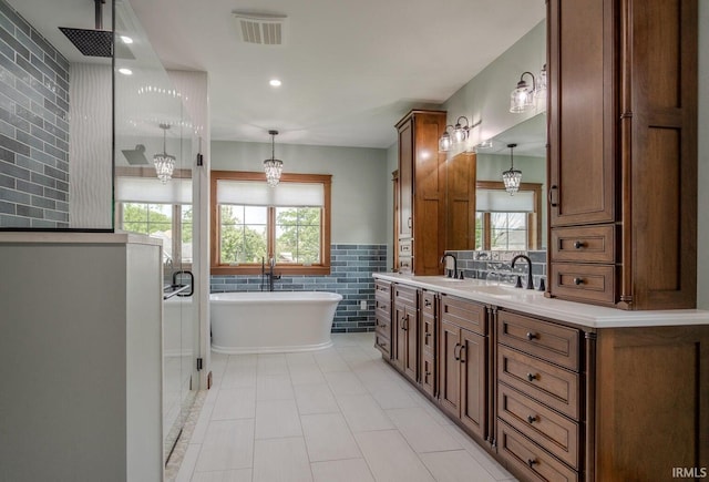 bathroom with vanity, plenty of natural light, tile walls, and separate shower and tub