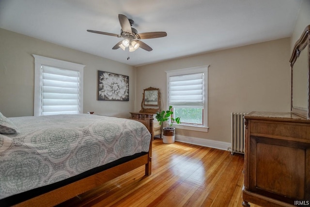 bedroom with radiator, ceiling fan, and light wood-type flooring