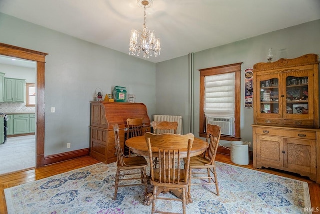 dining area with a chandelier, light hardwood / wood-style floors, and cooling unit