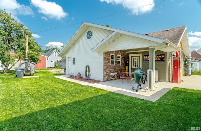 back of house with a patio and a lawn