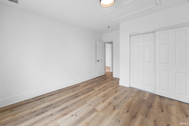 unfurnished bedroom featuring light hardwood / wood-style floors and a closet