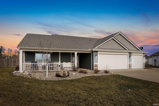 view of front of house with a yard, a garage, and a porch