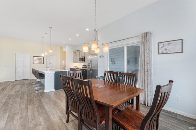 dining space featuring wood-type flooring and sink