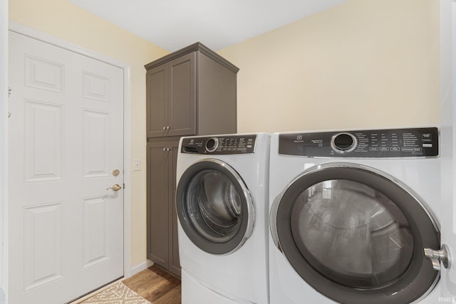 washroom featuring cabinets, separate washer and dryer, and hardwood / wood-style floors