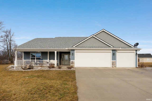 view of front of property with a garage, covered porch, and a front lawn