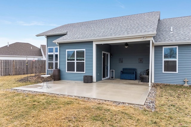 back of property featuring ceiling fan, a patio, and a lawn