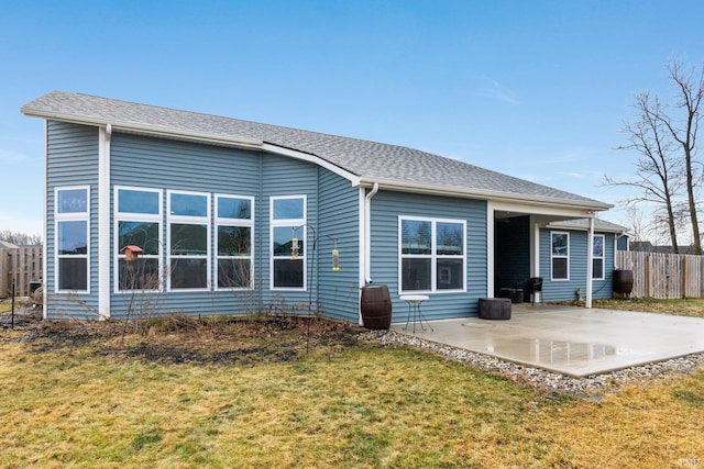 rear view of house with a lawn and a patio