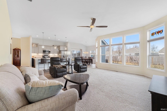 carpeted living room with plenty of natural light and ceiling fan