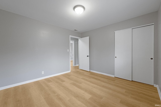 unfurnished bedroom with light hardwood / wood-style floors and a closet