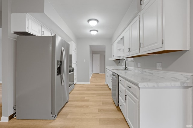 kitchen featuring stainless steel appliances, sink, white cabinets, and light hardwood / wood-style floors