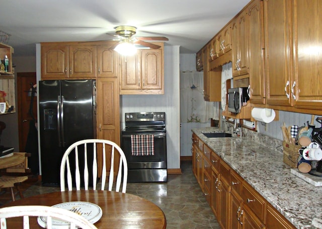 kitchen featuring light stone counters, sink, ceiling fan, and appliances with stainless steel finishes