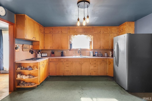 kitchen with pendant lighting, sink, and stainless steel fridge