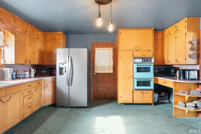 kitchen with hanging light fixtures, stainless steel refrigerator with ice dispenser, and double wall oven