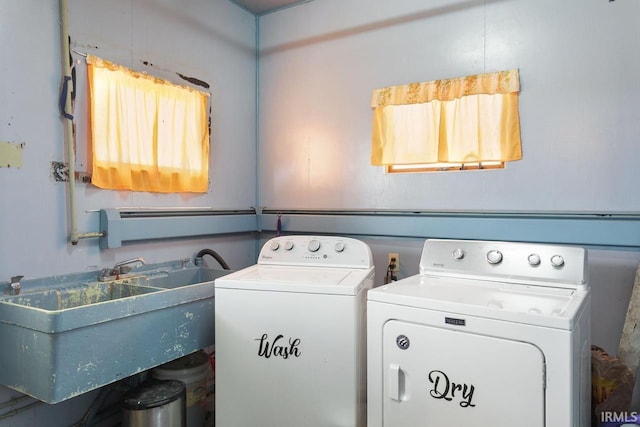 laundry area featuring plenty of natural light, sink, and washer and dryer