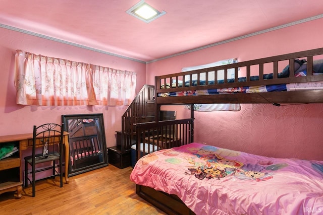 bedroom with a baseboard radiator and hardwood / wood-style floors