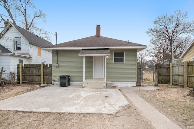 back of property with central AC unit and a patio area