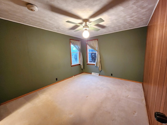 carpeted empty room featuring a textured ceiling and ceiling fan