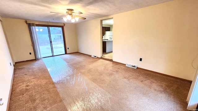 empty room featuring light colored carpet and ceiling fan