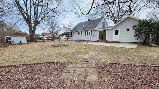 back of house featuring a shed, a yard, and a patio