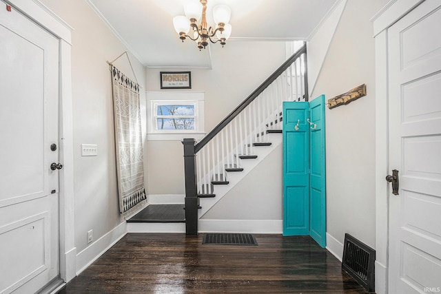 foyer with crown molding, a notable chandelier, and dark hardwood / wood-style flooring