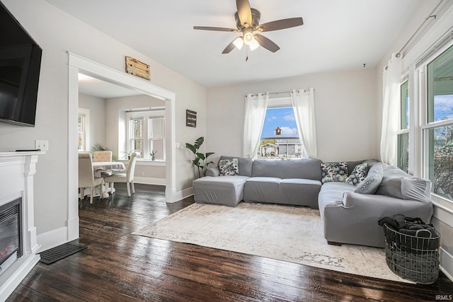 living room with dark wood-type flooring and ceiling fan