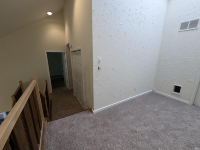 corridor featuring high vaulted ceiling and carpet