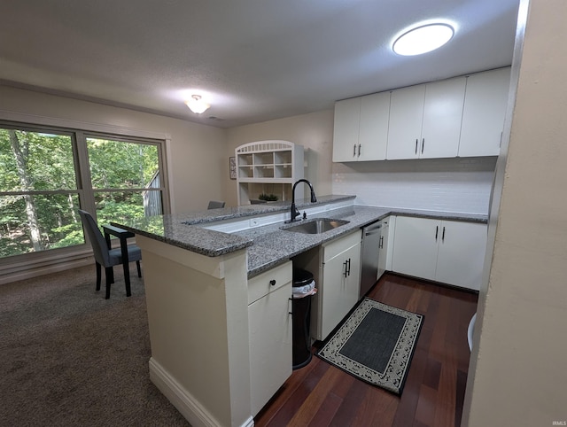 kitchen with sink, white cabinets, light stone counters, and kitchen peninsula