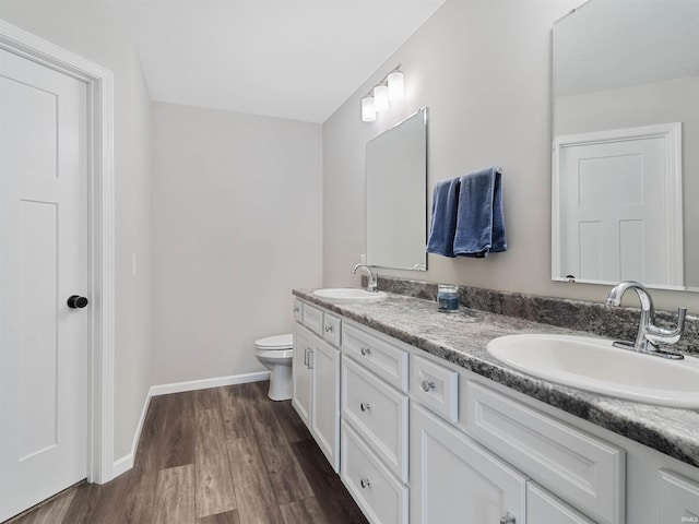 bathroom featuring wood-type flooring, vanity, and toilet